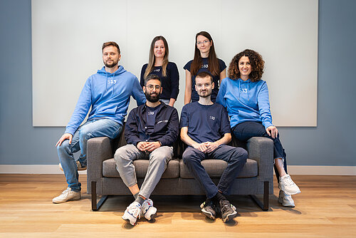 Teamfoto Startbahn 13 6 Personen sitzen auf einer Couch